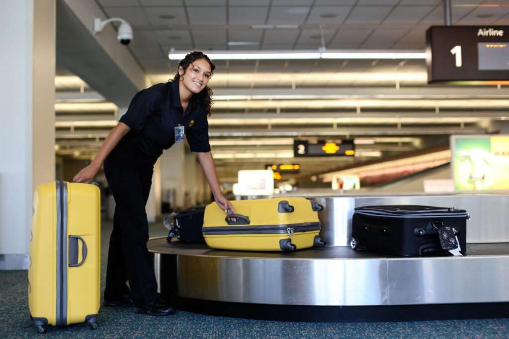 Employé de BAGs récupérant les bagages au comptoir de récupération des bagages