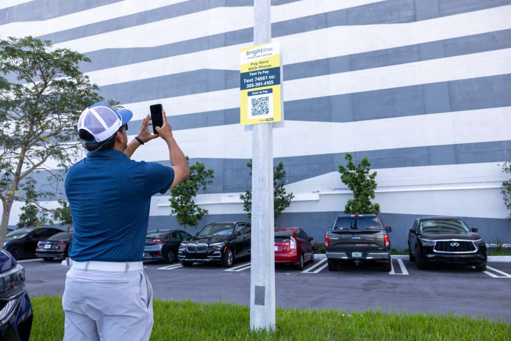 Homme scannant le texte du code QR SP+ pour payer dans un parking